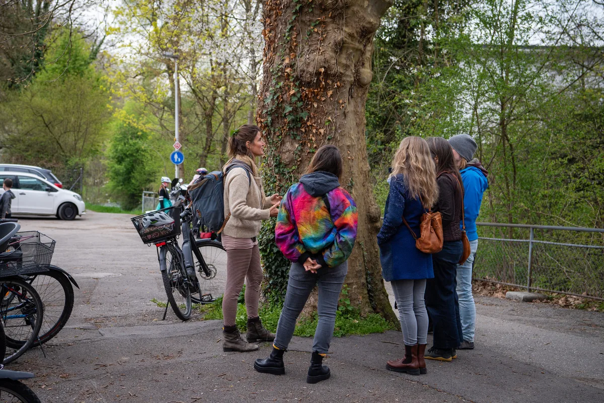 Eine Gruppe Menschen, die um einen Baum herum stehen.